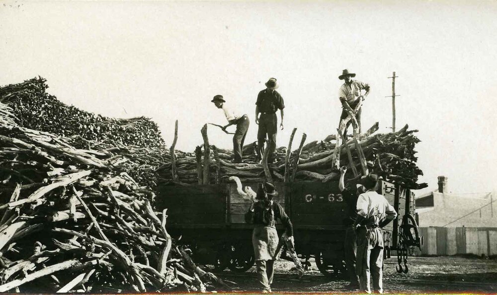 Men unloading sandalwood from railway wagon