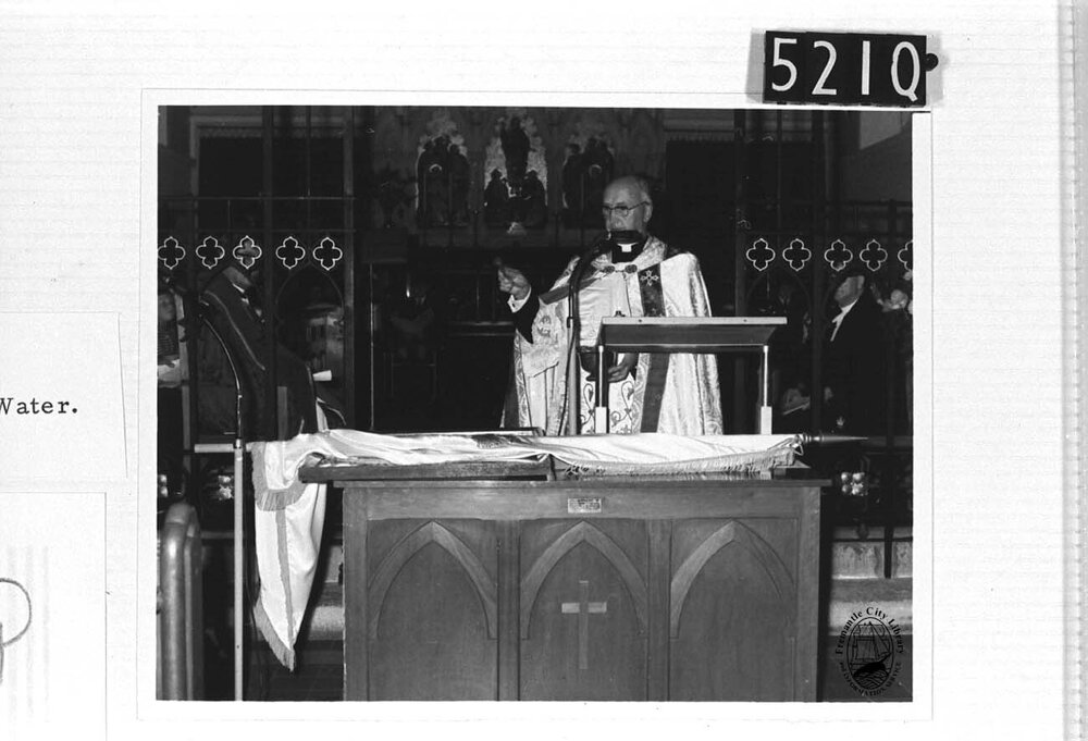 Rev. Father J. Burke sprinkles the Emblems with Holy Water