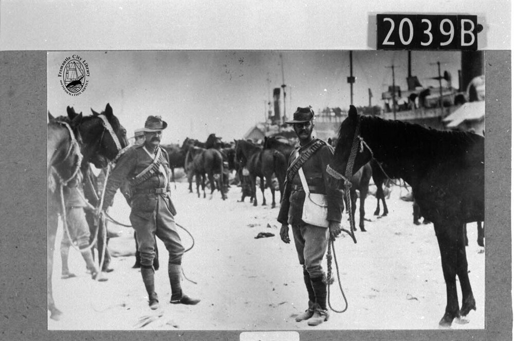 Mounted troopers wait with their horses