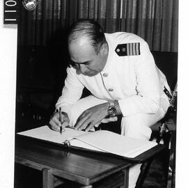 Captain Nei signs the visitors book