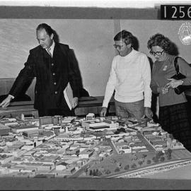 Council staff examining a model of the City
