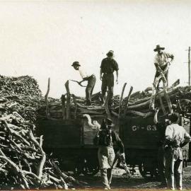Men unloading sandalwood from railway wagon